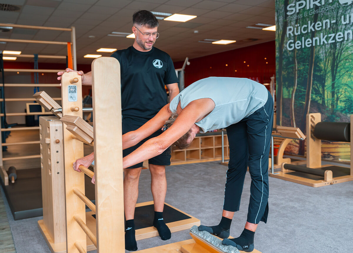Mitgliederin und Trainer bei einer Rückentraining Übung am five Gerät im SPIRIT4