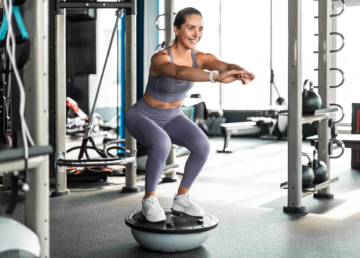 Mitgliederin bei einer Koordinationstraining-Übung mit einem Ballance-Board im SPIRIT4